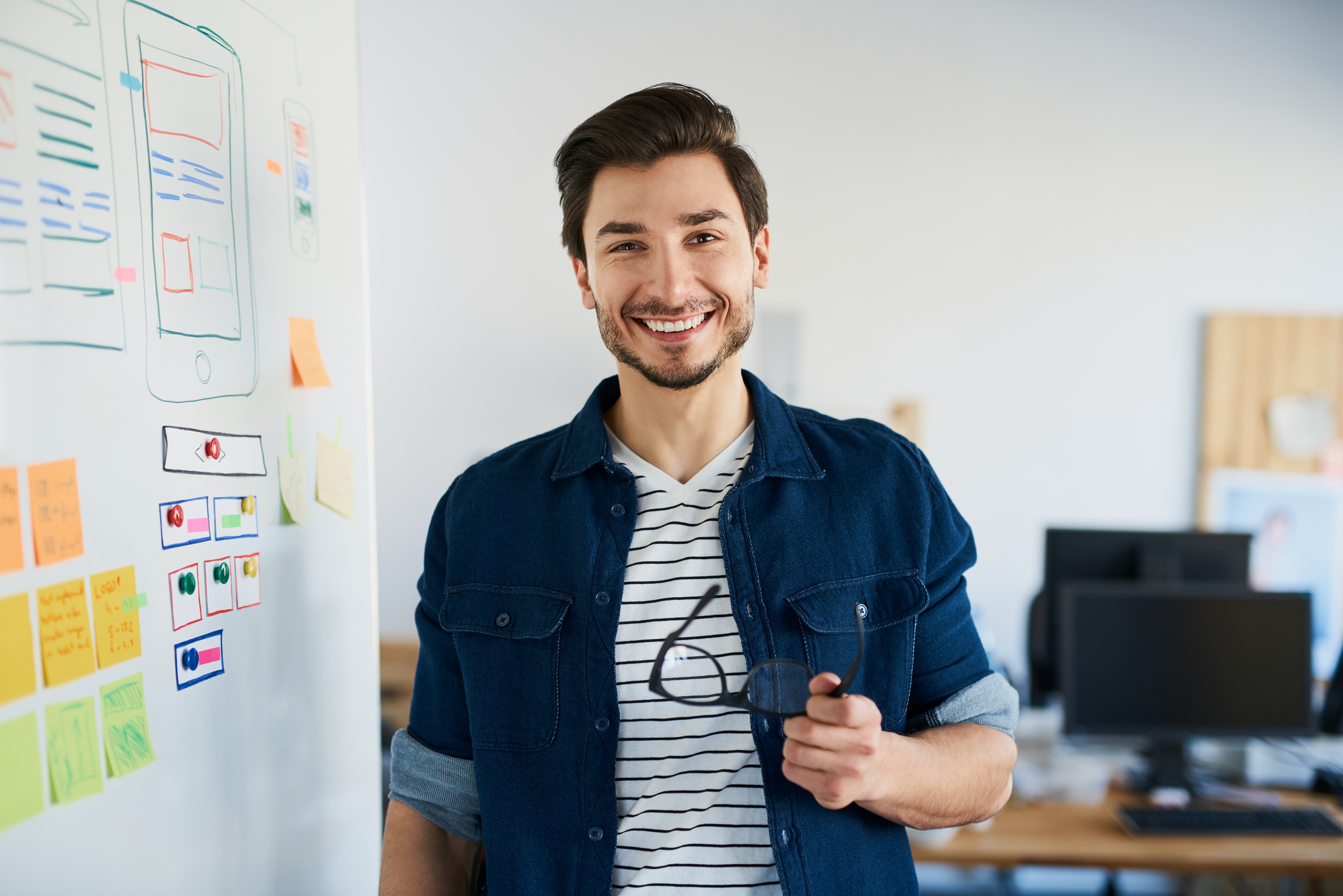 Happy web developer standing in office